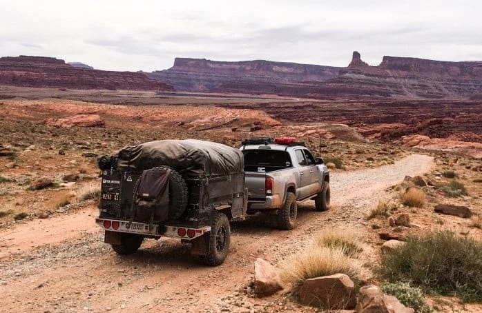 Toyota Tacoma towing a Patriot Campers trailer on a Moab dirt road